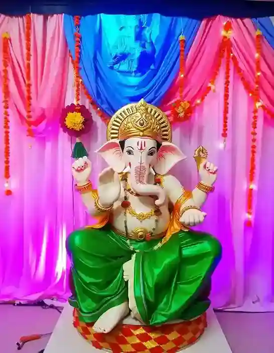 Traditional Ganpati idol decoration with green and pink backdrop and flower garlands for Ganesh Chaturthi | Traditional Ganpati Decoration with Flower Garland | Ganpati Decoration Ideas | Decorations Guru